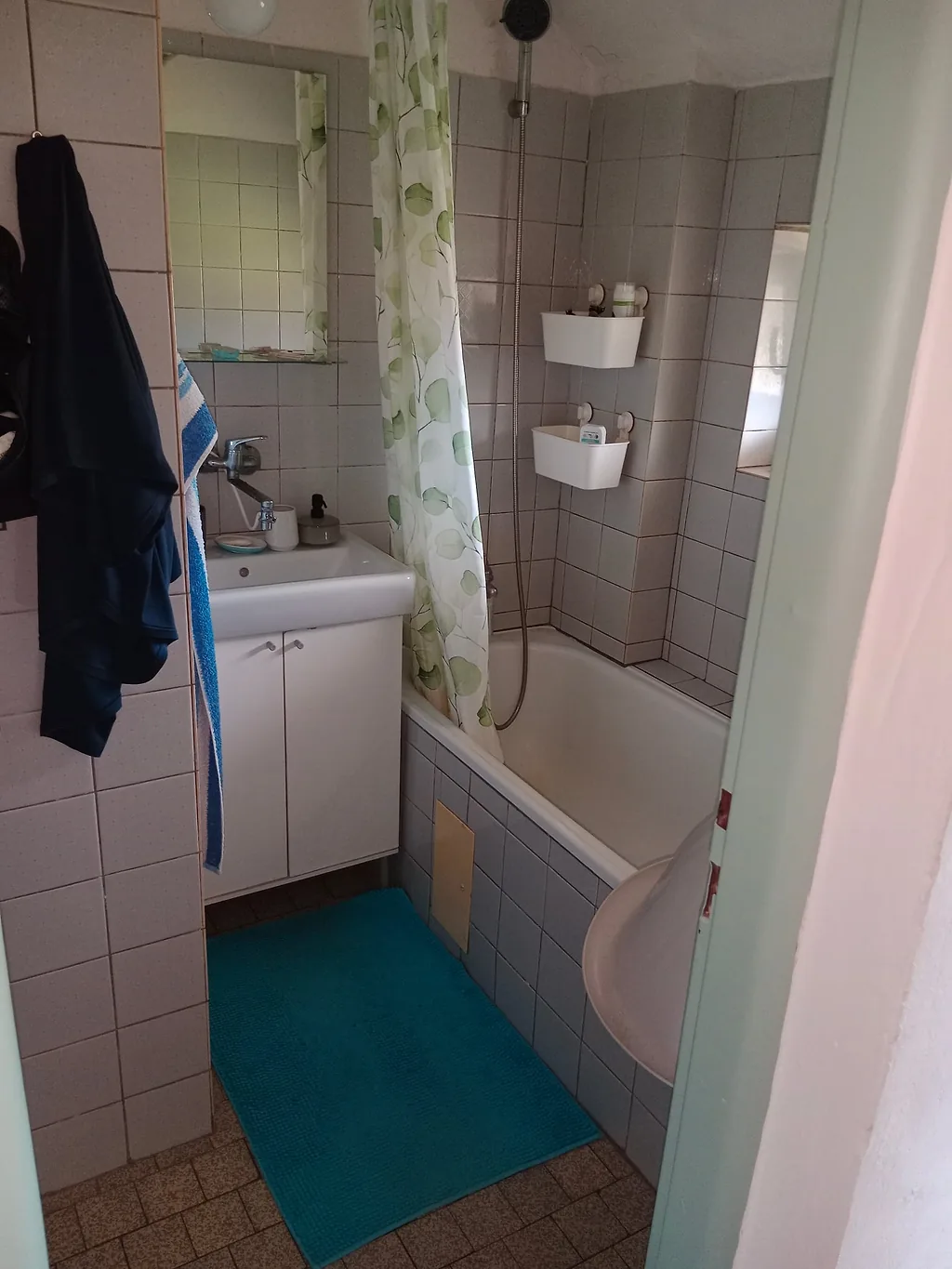 Původní koupelna s vanou, závěsem a malými bílými obklady